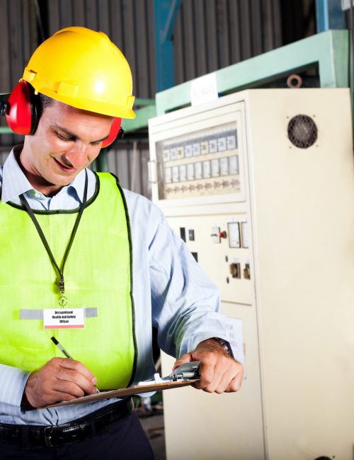 male occupational health and safety officer inside factory doing inspection